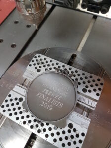 Rotary engraving a silver award medal with event name and winner