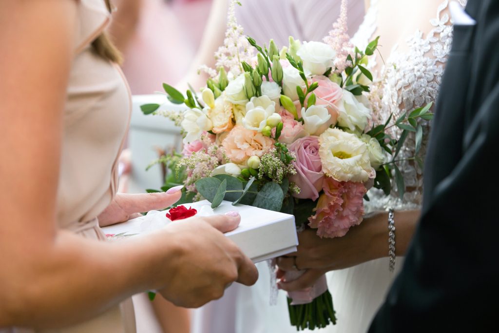 Personalized wedding gift being given to bride with flowers in background